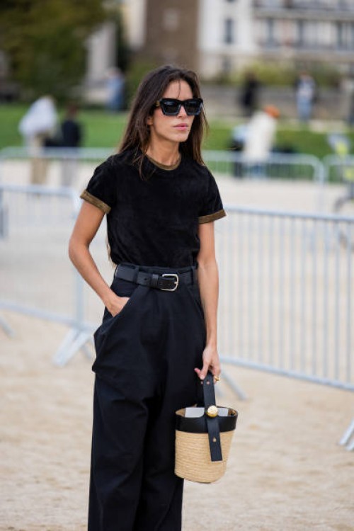 Nina Urgell Cloquell wears black shirt, high waisted pants, basket bag, sunglasses outside Loewe during Womenswear Spring/Summer 2025 as part of...