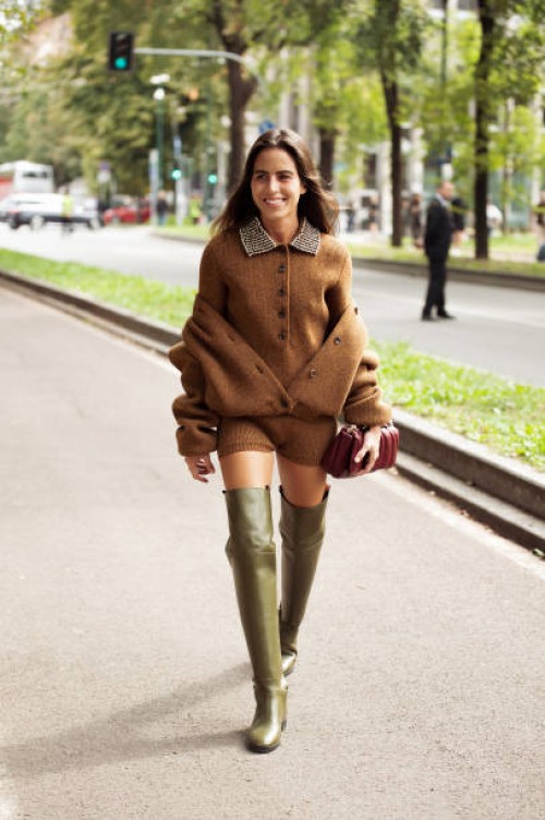 Nina Urgell Cloquell wears brown knitted mini shorts, brown top and sweater on top, long green shoes, burgundy Gucci bag outside Gucci show during...