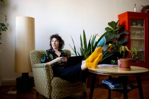 non-binary person listening to music while working on laptop at home - fashion photos et images de collection