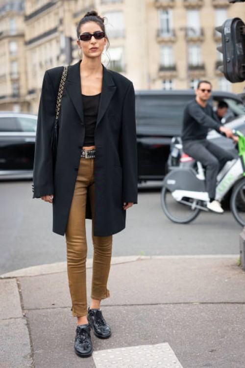 Nora Attal wears a black tank top, black long blazer, tan skinny jeans and black shoes, outside Chanel, during the Haute Couture Fall/Winter...