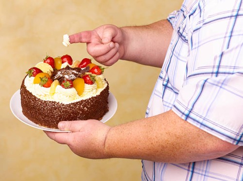 obese man holding fruit gâteaux with cream on - junk food stock pictures, royalty-free photos & images