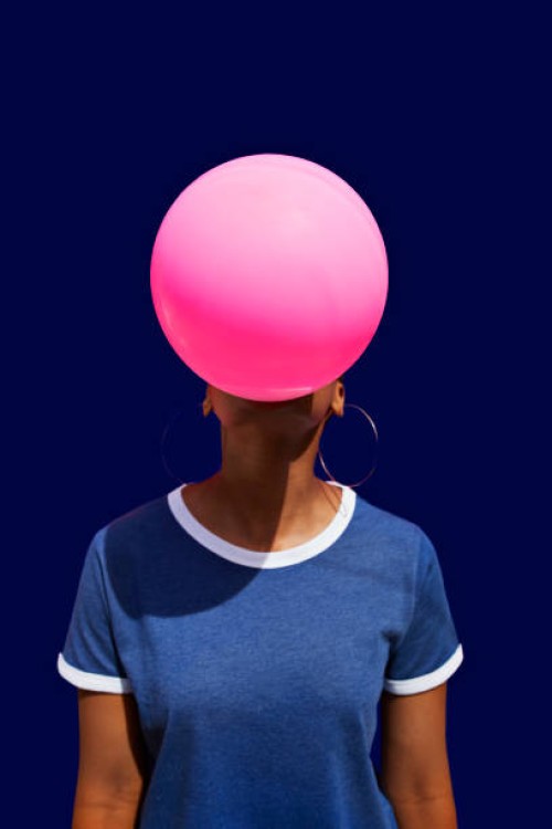 obscured face of woman blowing balloon - fashion stock pictures, royalty-free photos & images
