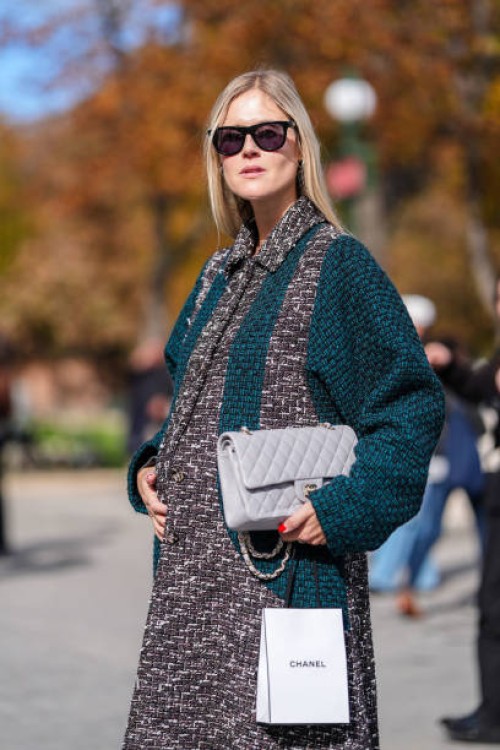 October 1 : Linda Tol wears black sunglasses, dark gray white pattern dark green tweed Chanel coat, light gray quilted Chanel leather bag, black...