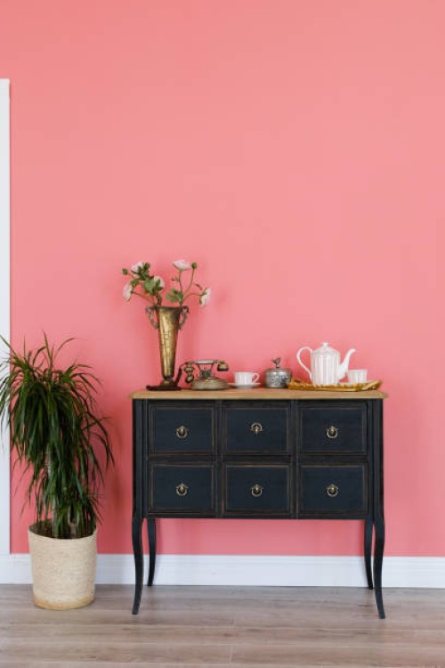 old chest of drawers with objects on the background of a pink wall. next is a flower in a pot. beautiful interior in vintage style. - home decoration stock pictures, royalty-free photos & images