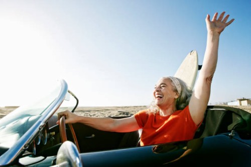 older caucasian woman in convertible car with surfboard on beach - travel stock pictures, royalty-free photos & images