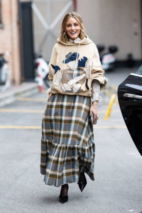 Olivia Palermo is seen wearing black tights, black leather pumps with a bow application on the point, a gold chain bracelet, a white cream and black...