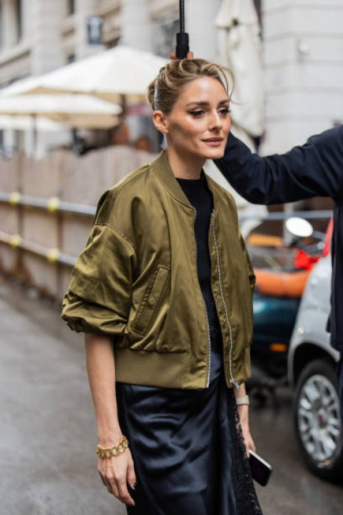 Olivia Palermo wears black laced dress, green bomber jacket outside Del Core during the Milan Fashion Week Menswear Spring/Summer 2025 on September...