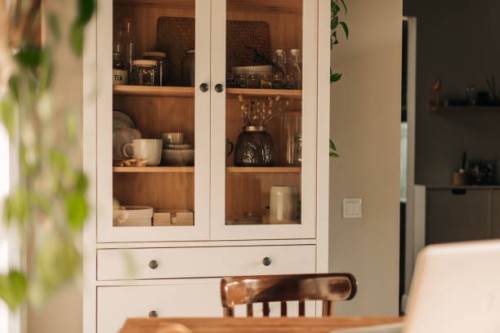 opened white glass cabinet with clean dishes and decor. scandinavian style kitchen interior. organization of storage in kitchen. - home decoration stock pictures, royalty-free photos & images