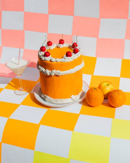 orange cake with milk cocktail and citric fruit on multicolored checkered background - food stock pictures, royalty-free photos & images