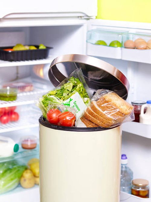out of date food in garbage bin in-front fridge - food stock pictures, royalty-free photos & images