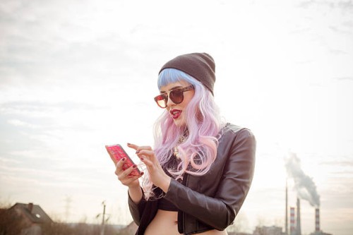 outdoor portrait of blue-pink hair cool girl texting on phone - fashion stock pictures, royalty-free photos & images