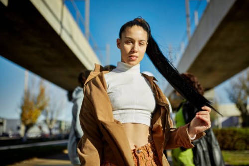 outdoor portrait of early 20s woman with long black ponytail - fashion stock pictures, royalty-free photos & images