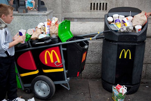 Overflowing bins full of rubbish, waste from a nearby MacDonalds fast food store. At Waterloo, the tourists flock in huge crowds, buying junk food...