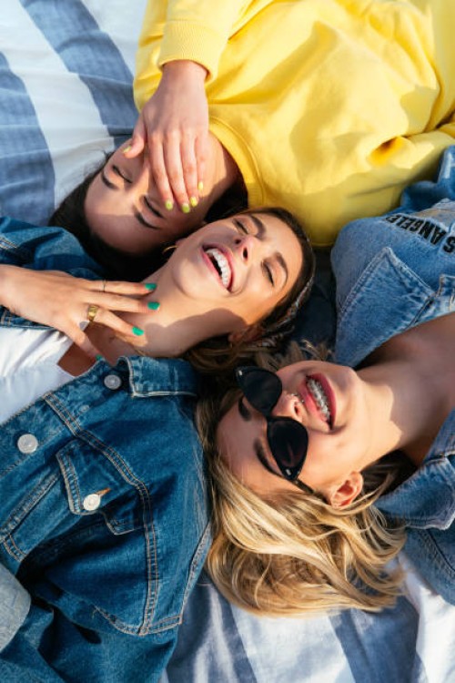 overhead portrait of smiling friends having fun lying on the beach - fashion stock pictures, royalty-free photos & images