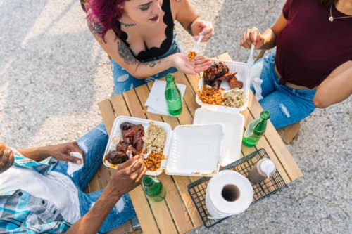 overhead view of a multiracial group of friends sharing a meal eating together outdoors at a bbq food truck in houston, texas - junk food stock pictures, royalty-free photos & images
