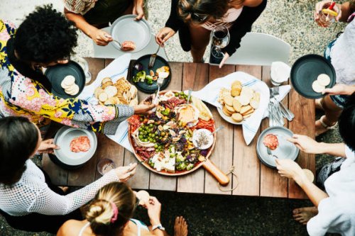 overhead view of group of friends enjoying buffet of food during party - food stock pictures, royalty-free photos & images