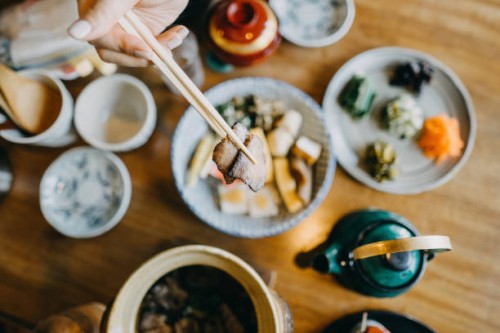 overhead view of woman enjoying delicate japanese cuisine with various side dishes and green tea in the restaurant - food stock pictures, royalty-free photos & images
