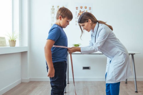 overweight boy with young female doctor in white coat - junk food stock pictures, royalty-free photos & images