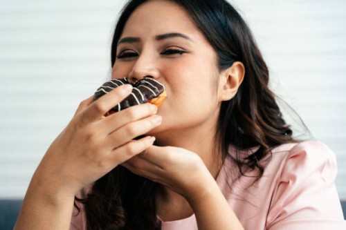 overweight happy woman with a donut - junk food stock pictures, royalty-free photos & images