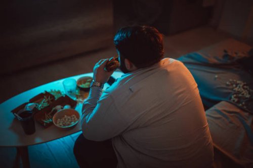 overweight man eating a burger - junk food stock pictures, royalty-free photos & images