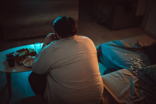 overweight man watching television - junk food stock pictures, royalty-free photos & images
