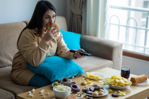 overweight woman sitting on sofa - junk food stock pictures, royalty-free photos & images