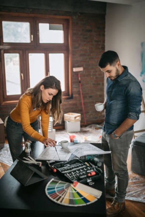paar kijken naar renovatieplannen op hun nieuwe thuis - home decoration stockfoto's en -beelden