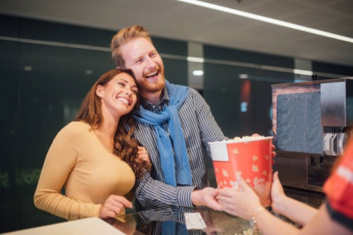 paar kopen popcorn in bioscoop - junk food stockfoto's en -beelden