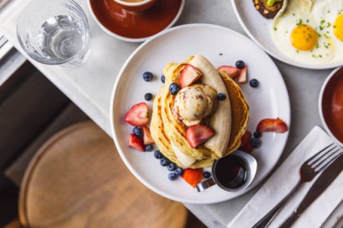 pancakes with banana, strawberry and blueberry served in a cafe for breakfast, high angle view - food stock pictures, royalty-free photos & images