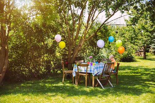 party table in garden with little boy - garden decoration stock pictures, royalty-free photos & images