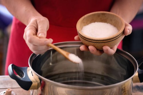 pasta cooking - chef puts sea salt into boiling pot, close up - food stock pictures, royalty-free photos & images