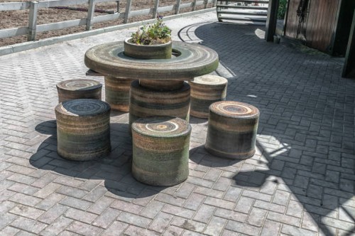 patio with stone round table - garden decoration stock-fotos und bilder