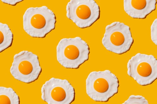 pattern of fried eggs against yellow background - food stock pictures, royalty-free photos & images