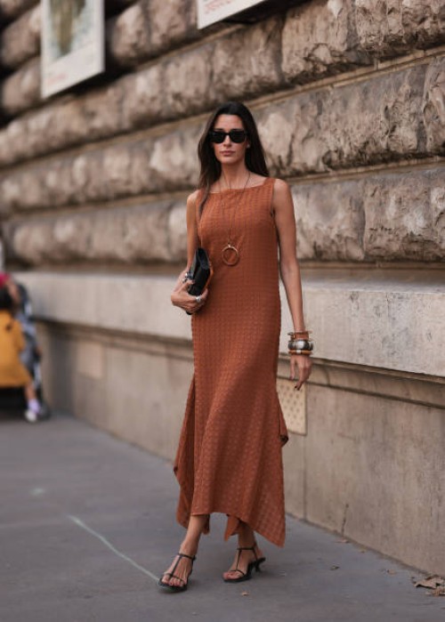 Paula Nata is seen outside Hermes show wearing black Rayban sunnies, brown long dress, black Hermes clutch, chunky gold and silver bracelets and...