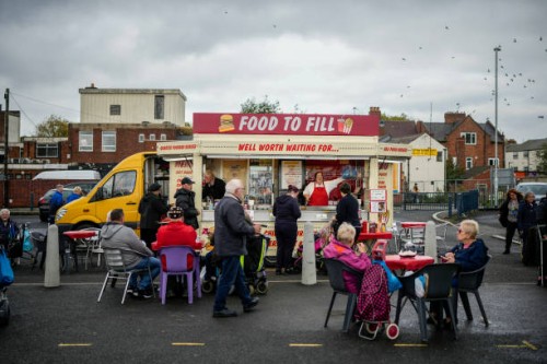 People eat fast food from a mobile caterer in Bilston on October 27, 2022 in Wolverhampton, England. A report from the Office for National Statistics...