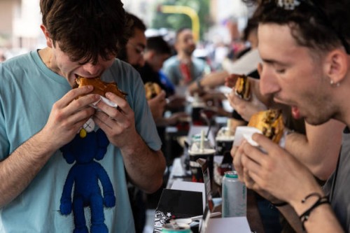 People eat hamburgers at Meat Crew fast food restaurant on May 28, 2023 in Milan, Italy. On occasion of the World Burger Day, celebrated on May 28...