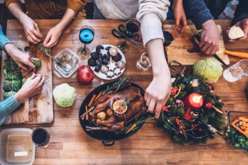people preparing vegetarian christmas meal and goose roast together on wooden kitchen table - food stockfoto's en -beelden