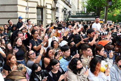 People stand across the street of the entrance of the 2024 Met Gala at the Metropolitan Museum of Art on May 6 in New York. The Gala raises money for...