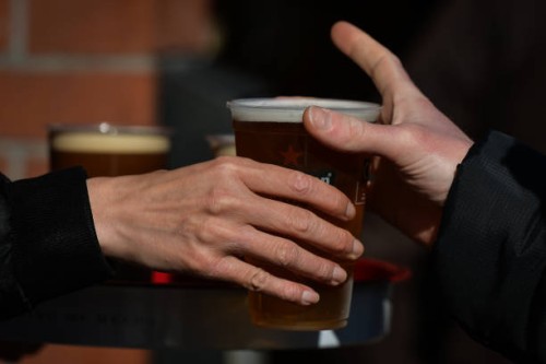 Person collecting a pint of lager beer in a plastic cup from the pub in Dublin's city center. On Thursday, 13 May 2021, in Dublin, Ireland.