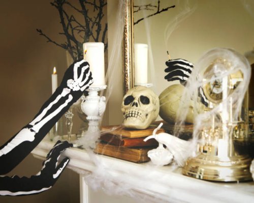 person dressed in a skeleton costume lights a candles. halloween composition on fireplace - home decoration stock pictures, royalty-free photos & images