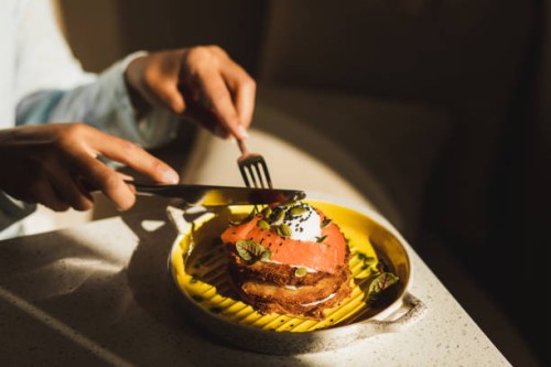 person eating hashbrown with salmon and poached egg. tasty and healthy breakfast. - food stock pictures, royalty-free photos & images