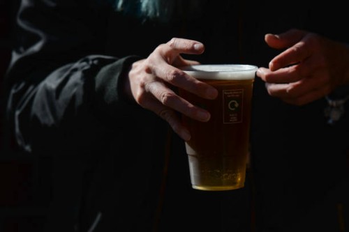 Person holds a pint of lager beer in a plastic cup from the pub in Dublin's city center. On Thursday, 13 May 2021, in Dublin, Ireland.