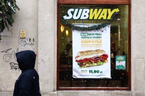 Person passes by Subway restaurant in Krakow, Poland on January 23, 2023.