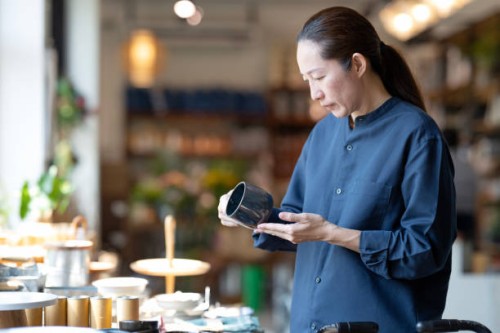 personalize your customer experience with an e-co-friendly product to increase your sales funnel. side view of a japanese customer deciding on a product made from recycled material at a retail display during shopping for home