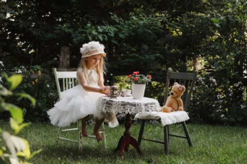 petite fille ayant un goûter dans un jardin - garden decoration photos et images de collection
