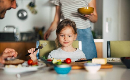 photo en gros plan d’une petite fille prenant le petit-déjeuner avec sa famille méconnaissable - food photos et images de collection
