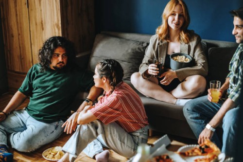photo of small group of university friends gathered together in dorm room to enjoy tasty - junk food stock pictures, royalty-free photos & images