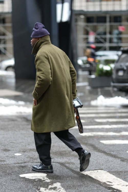 Photographer wears a navy blue beanie hat, a green khaki coat, outside Sandy Liang, during New York Fashion Week, on February 09, 2025 in New York...