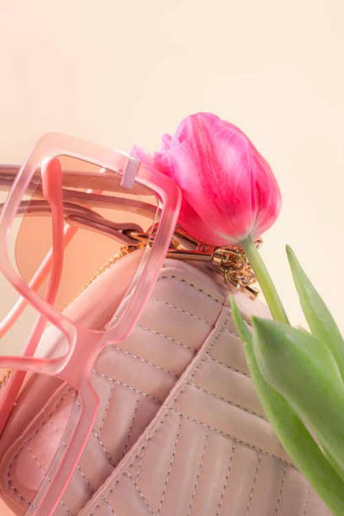 pink tulip flower, white beige leather shoulder bag or handbag and pink sunglasses on pastel beige color background. - fashion stock pictures, royalty-free photos & images