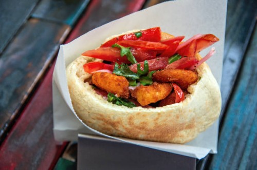 pita bread filled with breaded shrimp, sliced tomato, pickled red onion and arugula - junk food stock pictures, royalty-free photos & images